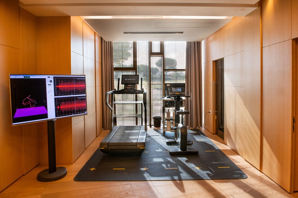 a room with a tv and treadmills
