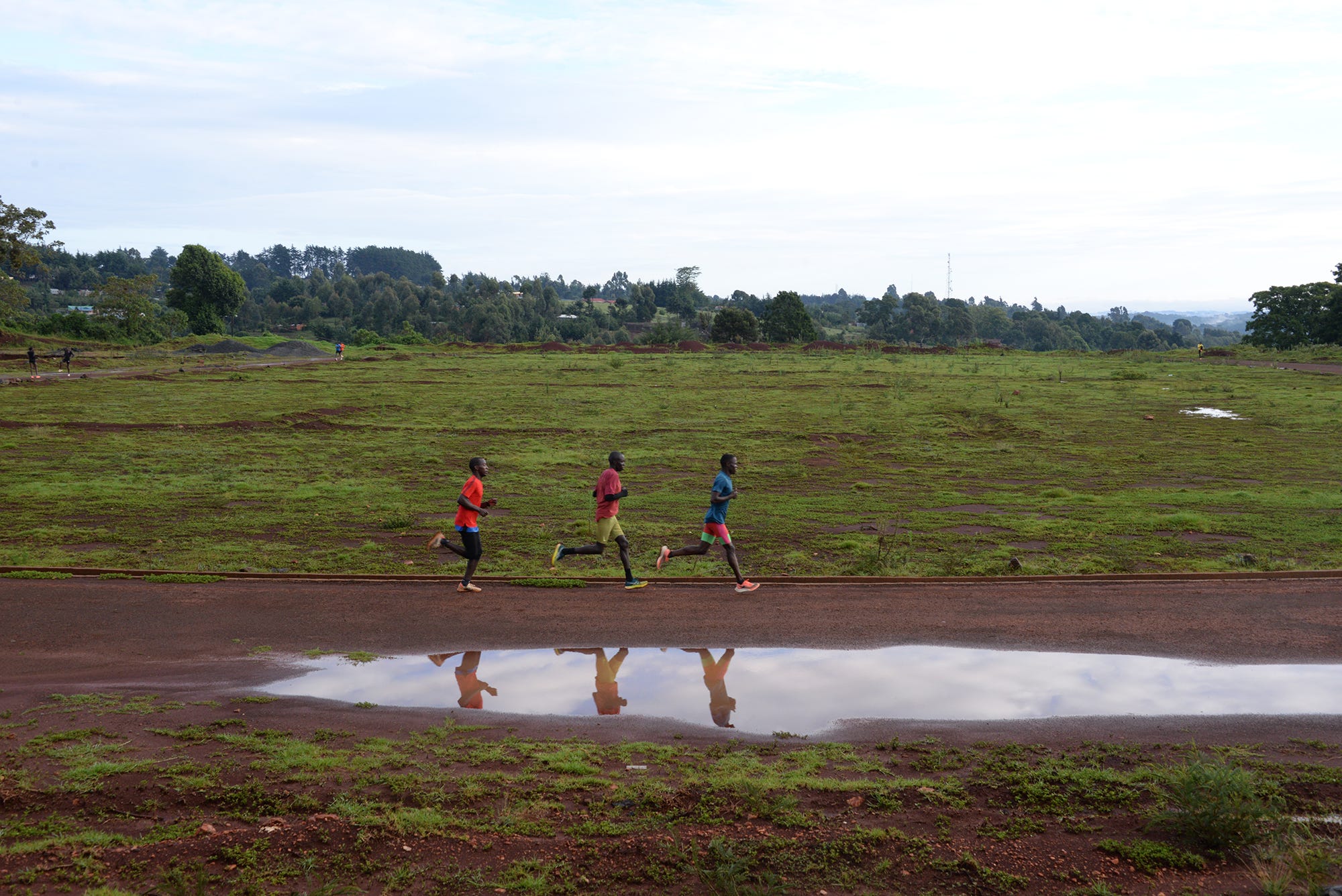 a group of people running on a dirt road