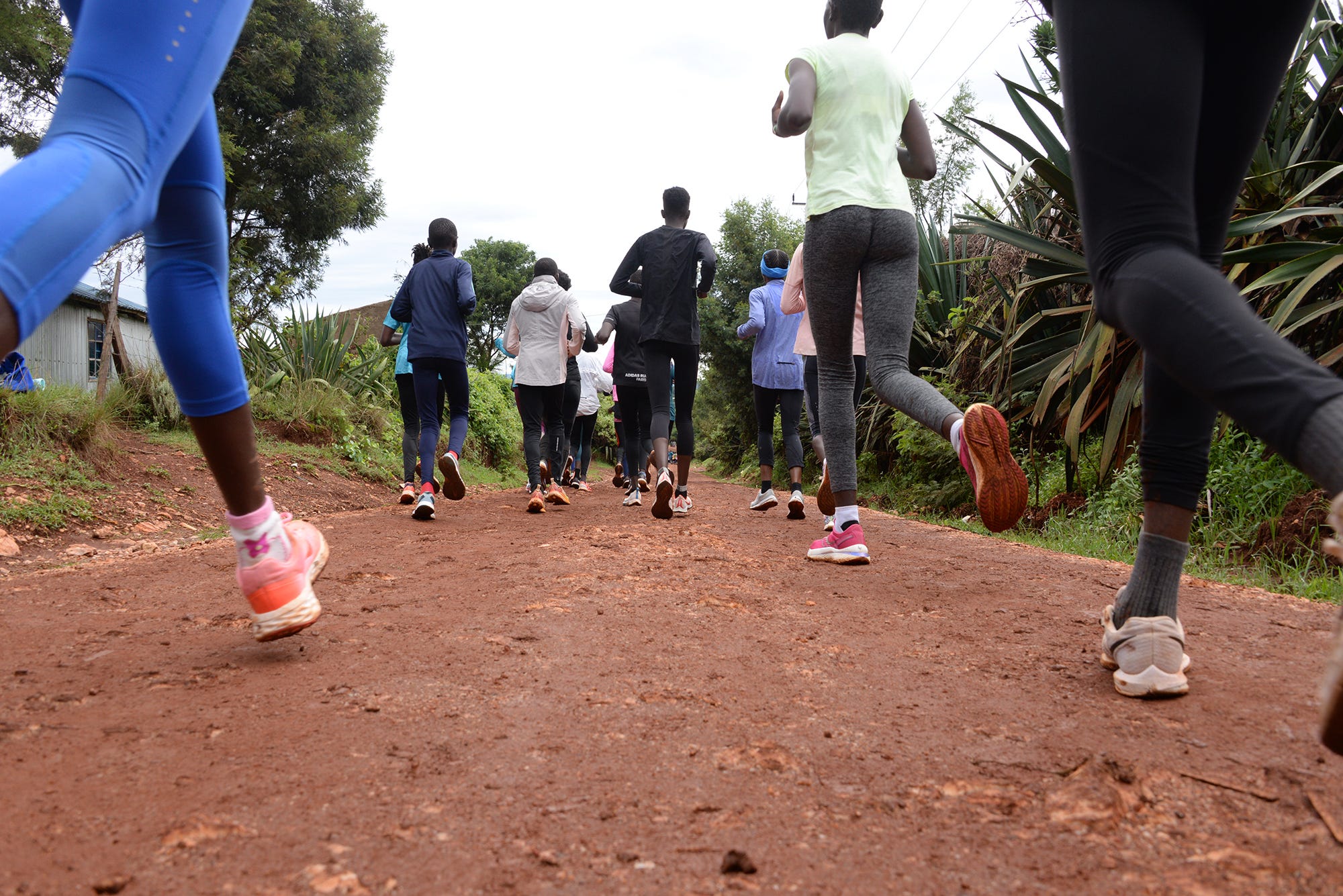 a group of people running on a dirt path