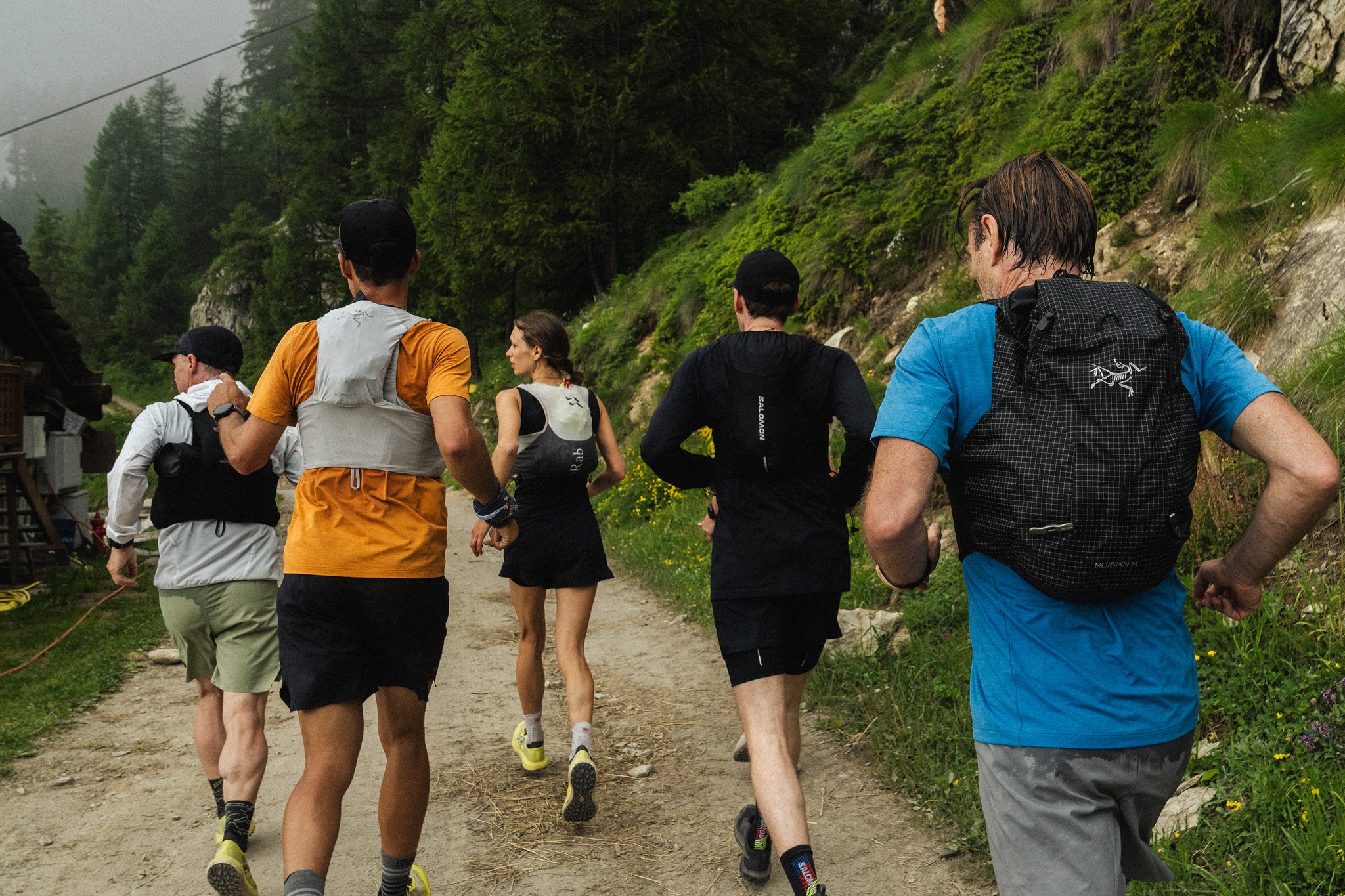 five runners on a path in the mountains