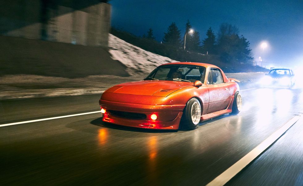 濡れた高速道路上のオレンジ色の車