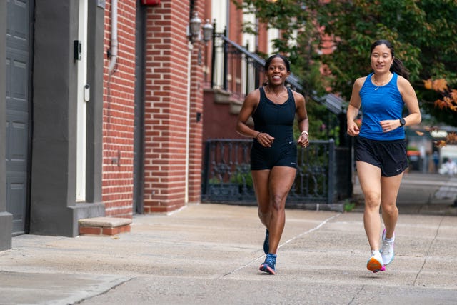 two women running together, smiling and talking