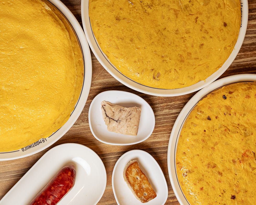 a spread featuring three large yellow frittatas accompanied by various side dishes