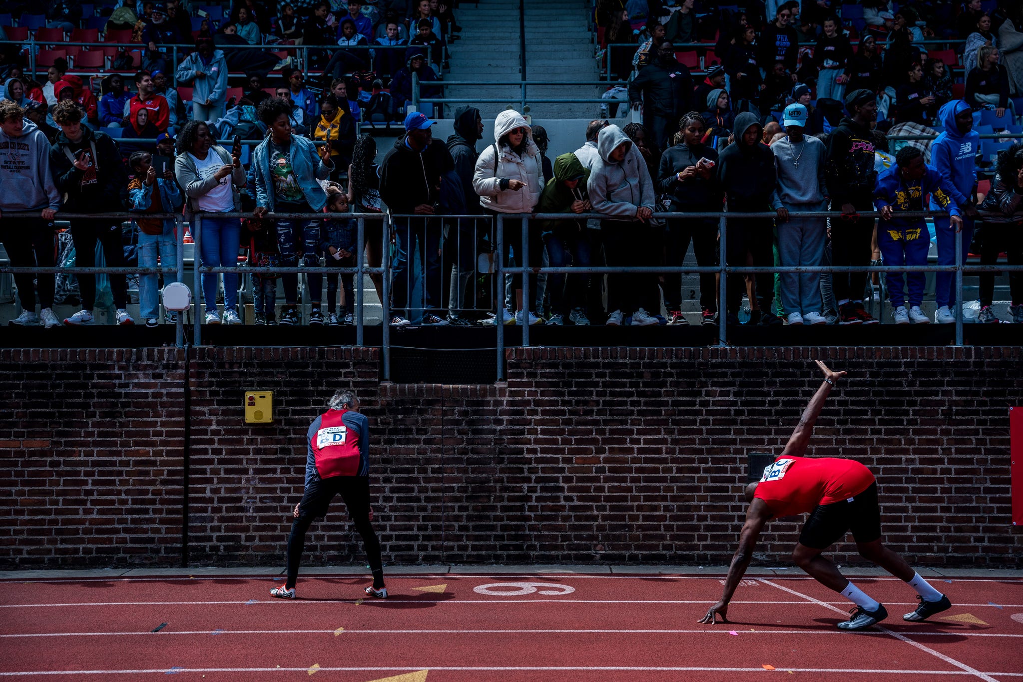 RWD a runner raises his hand to grab a baton in a relay race