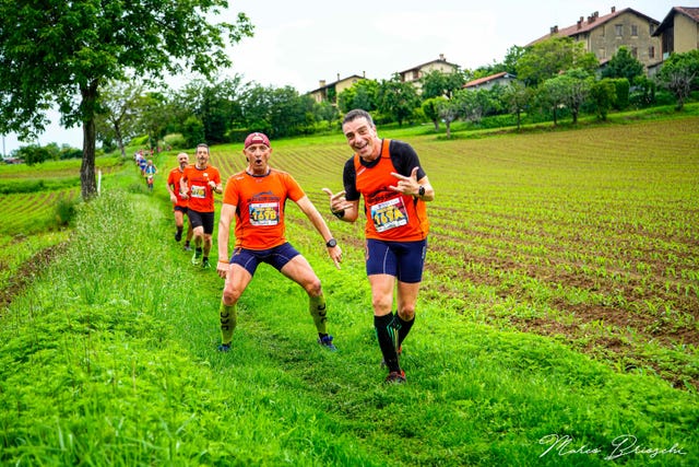 a group of men running on a grass field