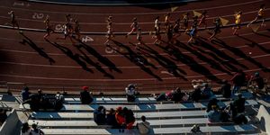 seen from above a group of runners on a track cast long shadows