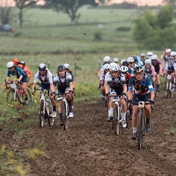 a group of cyclists on a muddy road