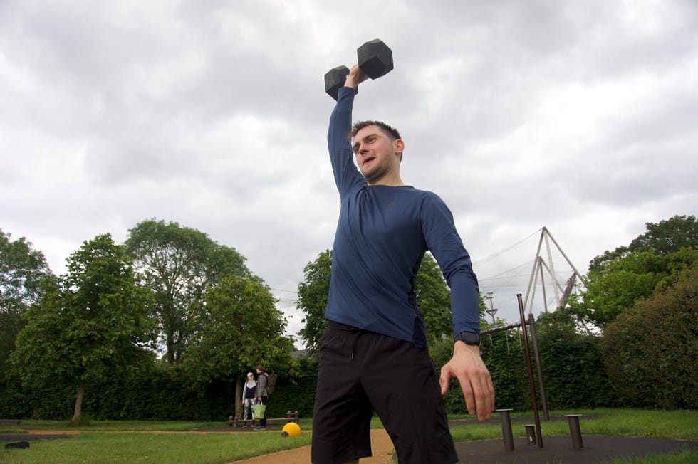 a man holding a black object up in the air