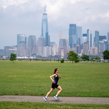 Runner speeding down a paved path with New York City in the background runner speeding down a paved path with new york city in the background