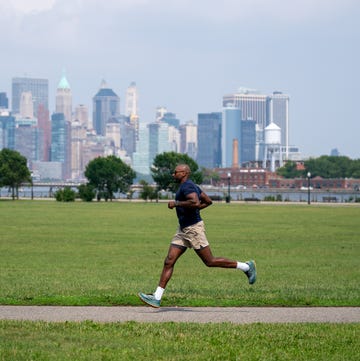 Runner on a path with a city skyline in the background runner on a path with a city skyline in the background