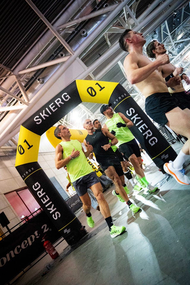athletes participating in a race under a branded arch