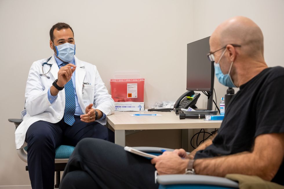 doctor speaking with the author, both wearing medical masks