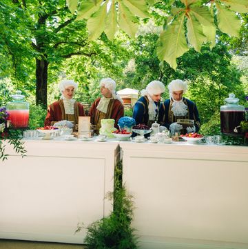 a group of people sitting at a table with food and drinks