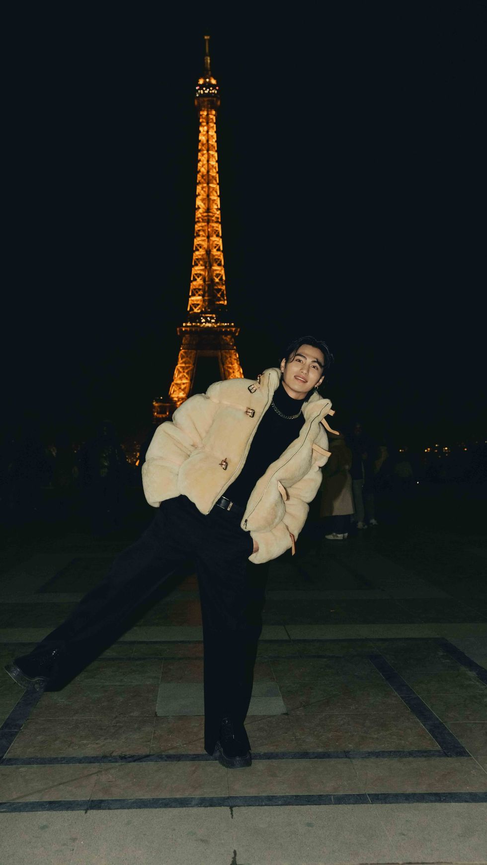a person posing in front of a tall tower