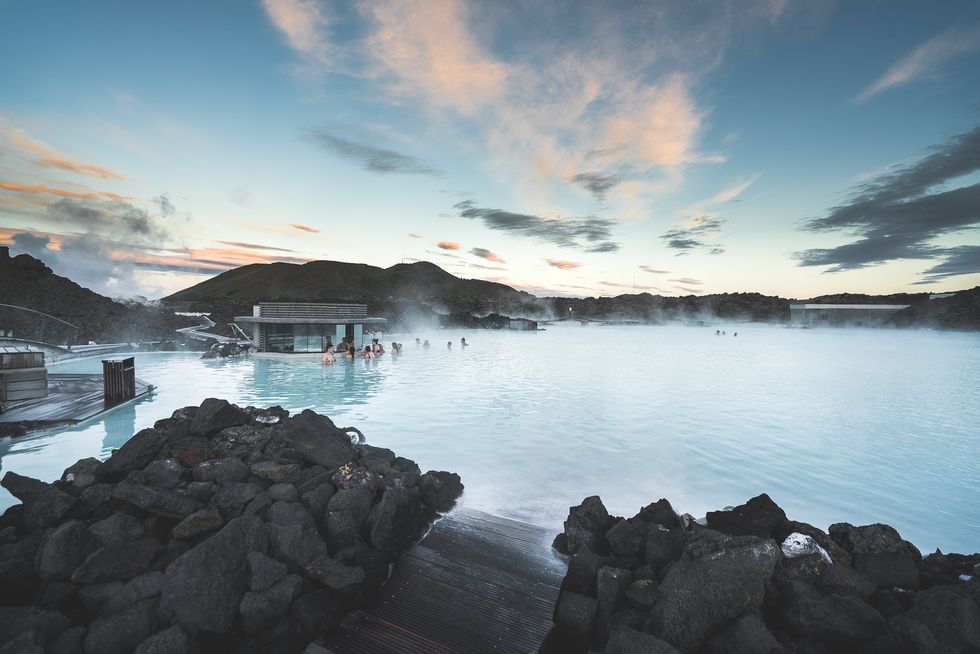 a body of water with a dock and buildings by it blue lagoon iceland