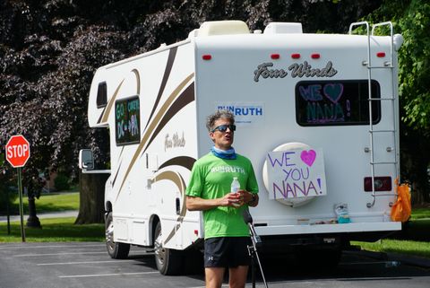 corey cappelloni pauses during a run by the rv that his girlfriend was driving a sign off the back of the rv reads, “we love you nana”