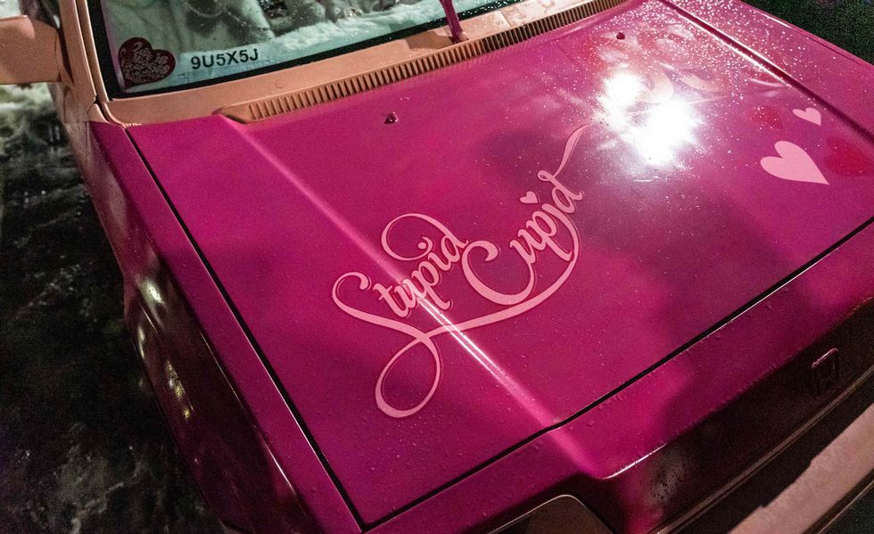 文字が書かれたピンクの車のボンネット