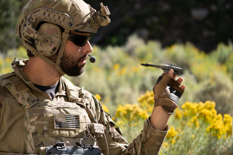 a man in military uniform holding a nanodrone