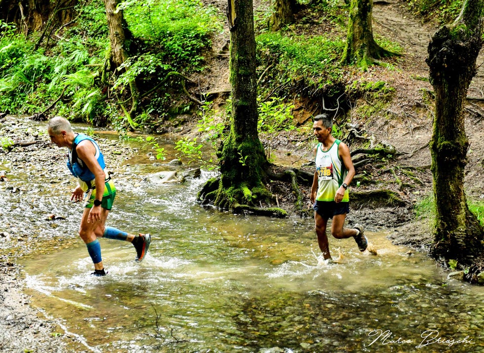 a couple of men running through a river