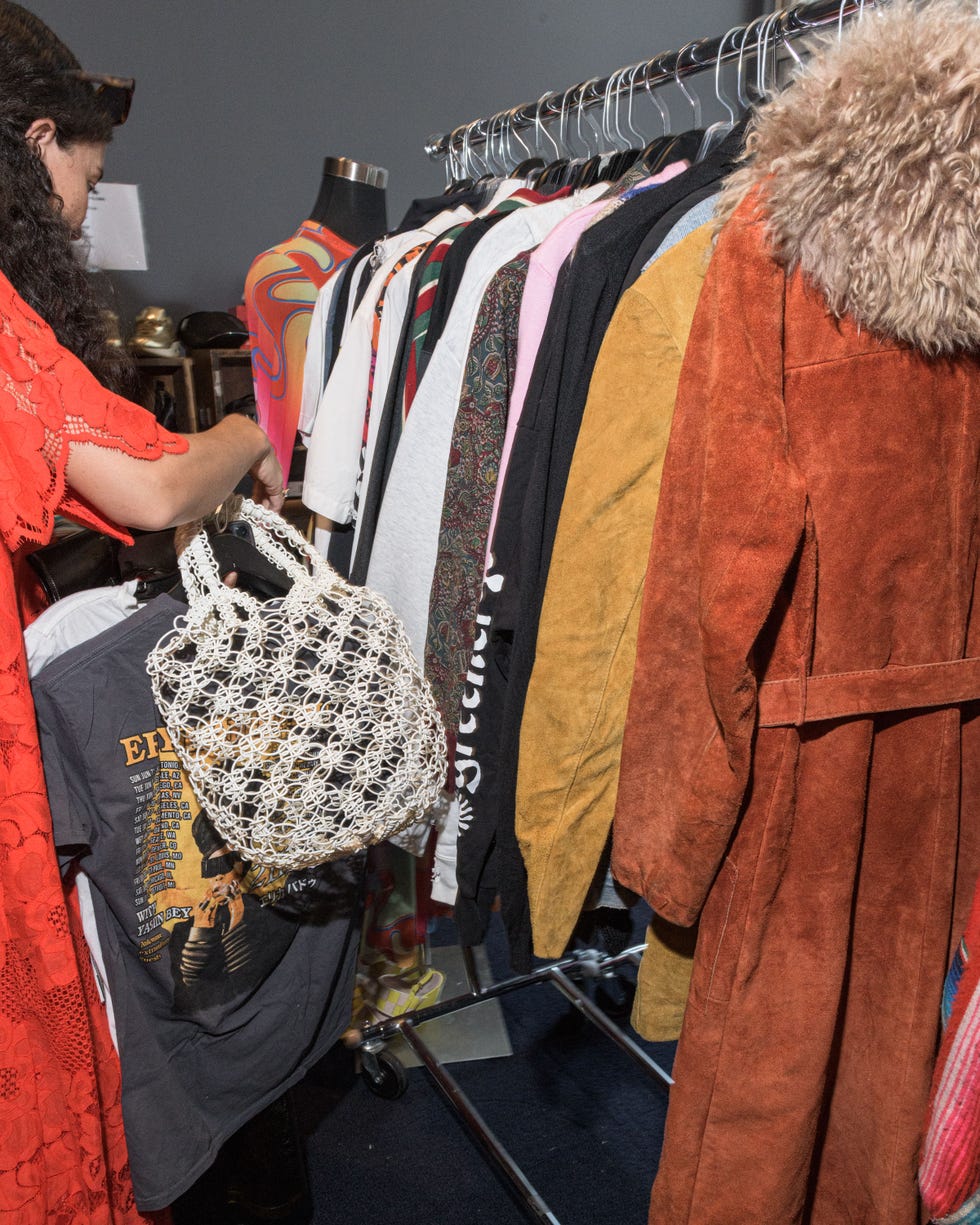 a group of people looking at a variety of clothing