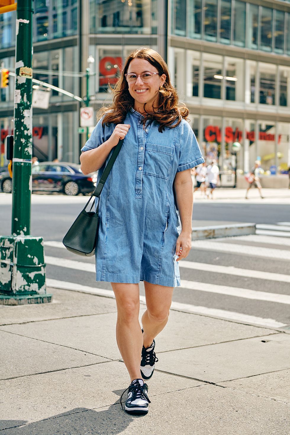 a bazaar editor wears a denim dress and air force ones to illustrate a guide to the best work outfit ideas