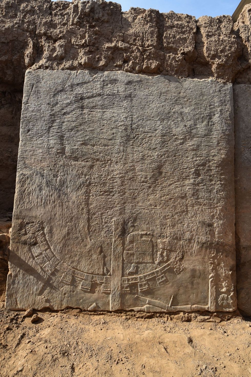 Aan deze opgegraven stenen plaat waar op een Assyrisch militair kamp staat afgebeeld is te zien hoe het grootste deel van het relif dat boven de grond uitstak is weggehakt