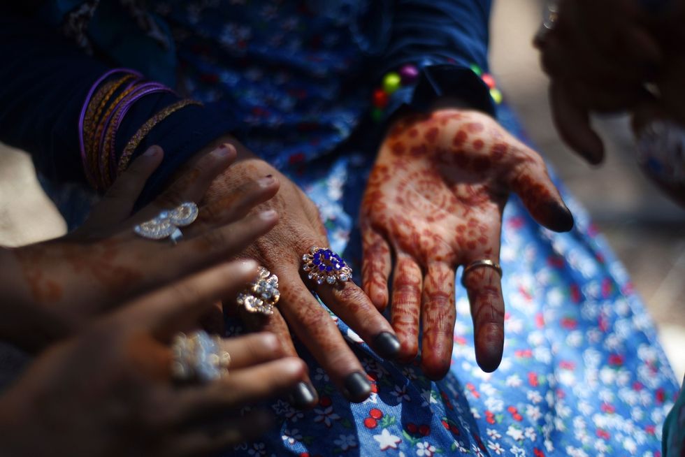 Jonge bedoeenenvrouwen hebben hun handen versierd met henna om de eerste dag van het Suikerfeest te vieren Door de slechte economische situatie zijn kostbare bedoeense accessoires van goud vervangen door ringen van plastic