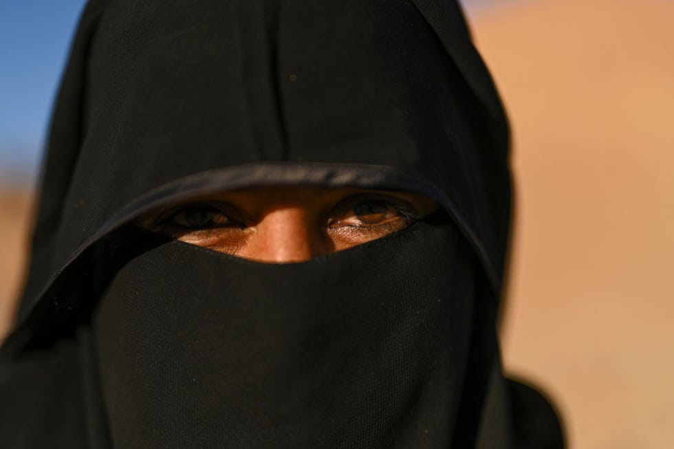 Yasmine Oem Mohammed poseert voor de foto in het dunbevolkte woestijngebied op het Egyptische schiereiland Sina het land van de bedoeenen Als moeder van vijf kinderen neemt ze deel aan een dorpsproject met het doel om aan de hand van borduurwerk en pozie de zelfexpressie van haar cultuur te bevorderen Ze komt uit Sjeik Awad een van de vele dorpen in de Sina die nog altijd geen elektriciteit en waterleiding hebben