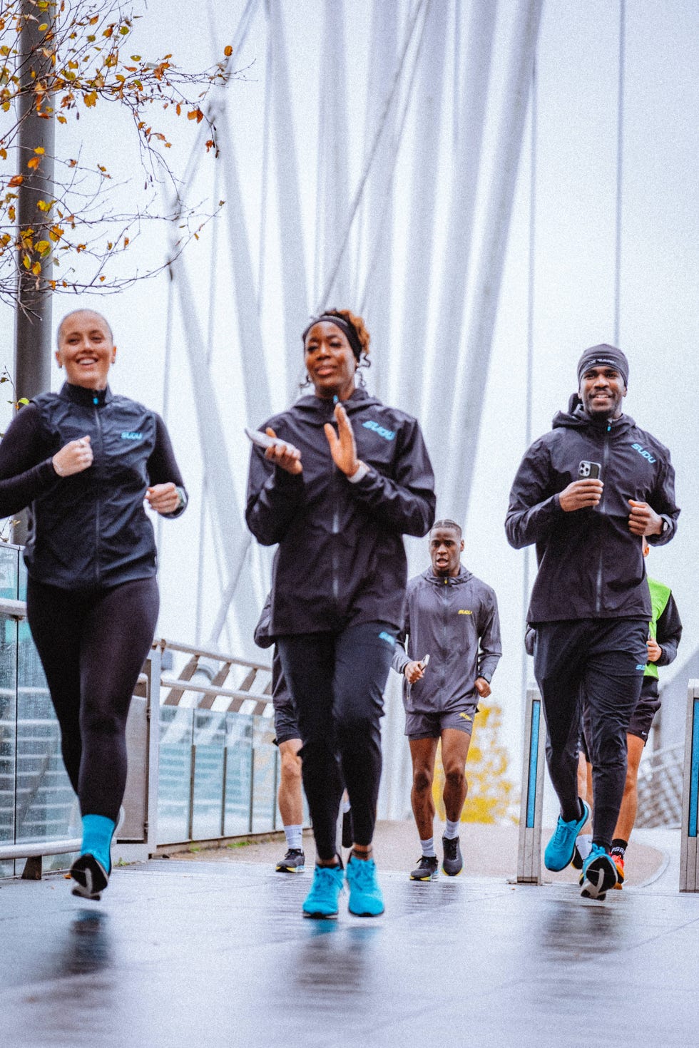 small group of smiling runners moving through an urban environment