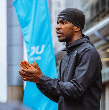 runner wearing a waterproof jacket and beanie hat beside a banner runner wearing a waterproof jacket and beanie hat beside a banner