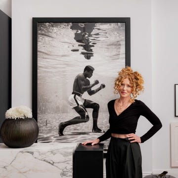 a person standing beside a large black and white photograph of a boxer
