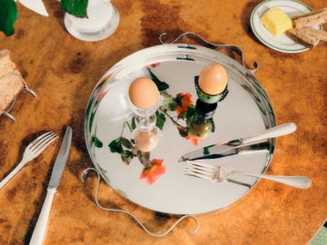 breakfast setting featuring a tray with two eggs and utensils