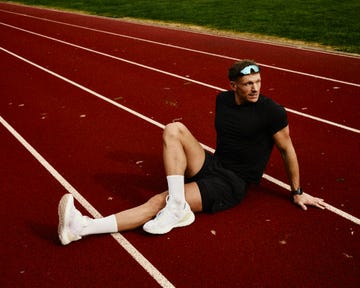 athlete resting on a running track after a workout