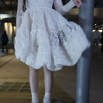 a model wears cecilie bahnsen asics sneakers with a white embellished dress coated in sequins