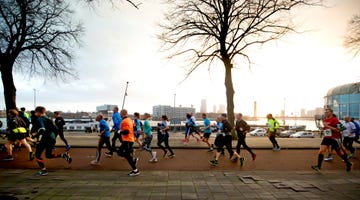 hardlopers langs kade rotterdam tijdens de bruggenloop