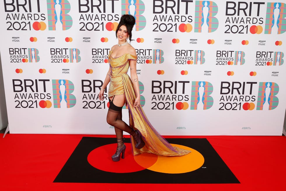 dua lipa wears a high pompadou hairstyle at an event, a wedding guest hairstyle inspiration