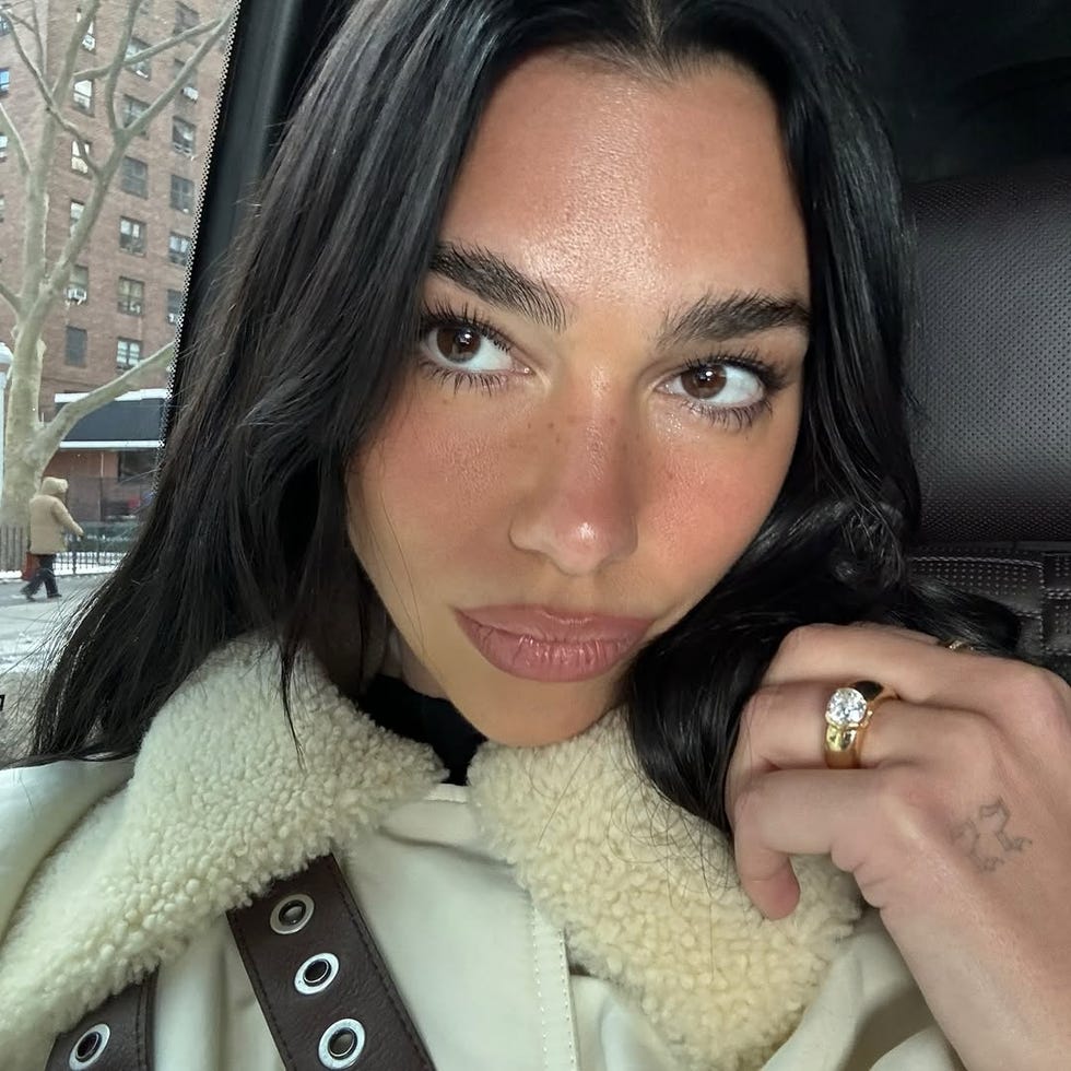 dua lipa wears a gold and diamond engagement ring