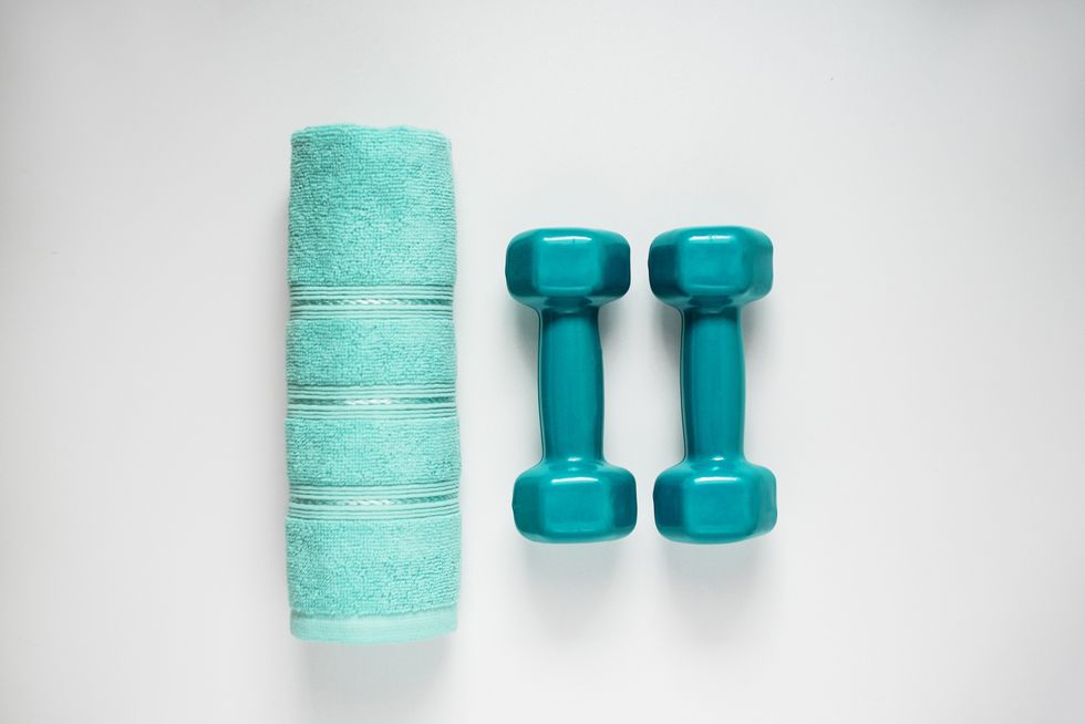 dumbbell and towel on white background