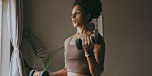 dumbbell exercise, black woman and workout in home, bedroom and apartment for strong body, muscle and wellness young female person, sports fitness and weights in house for power, training and focus