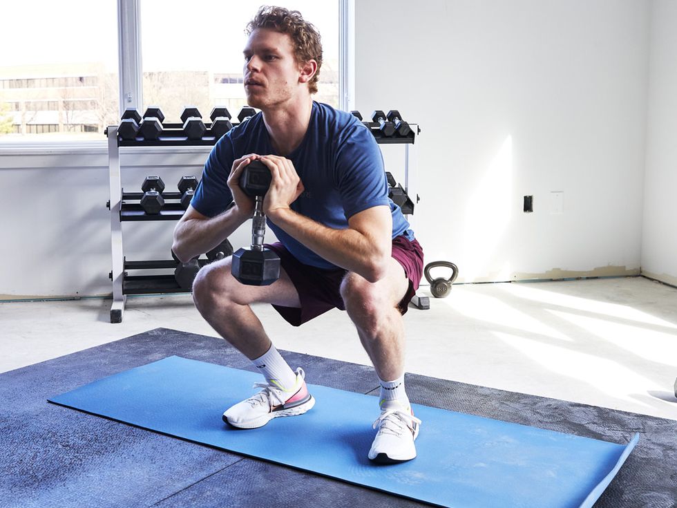man doing squats with single dumbbell