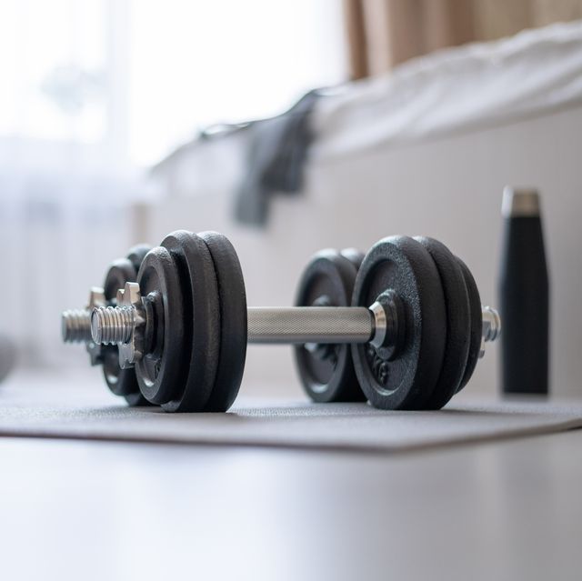 dumbbells, mat, water, on the floor in the bedroom preparing for home sports