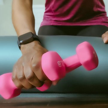 hand with smartwatch grabbing set of pink 2 pound weights
