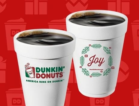 two white cups with green text on them