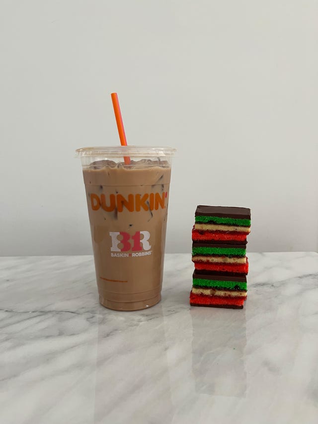 iced dunkin latte next to a stack of rainbow cookies