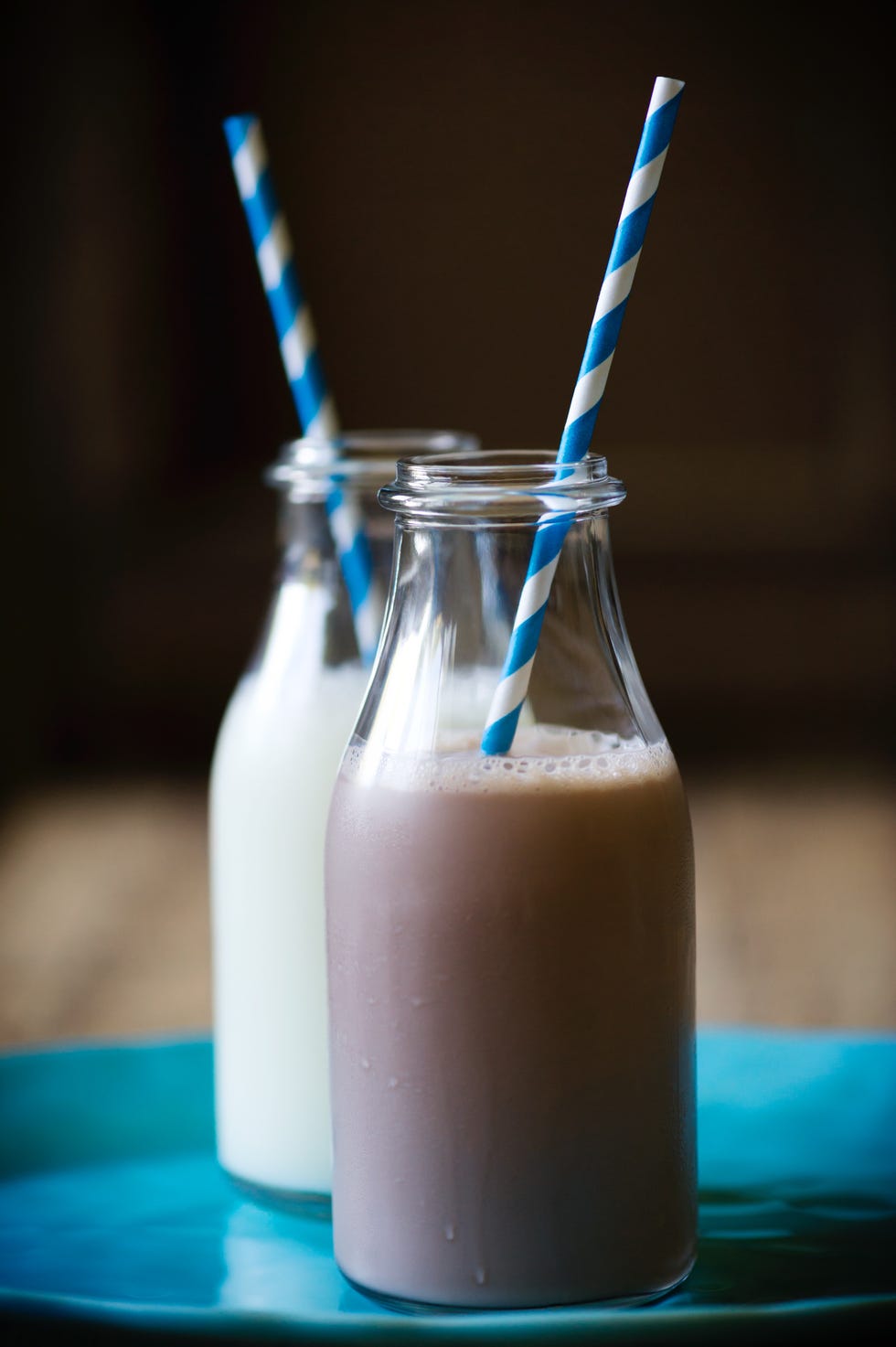 duo of milk and chocolate milk bottles with paper straws