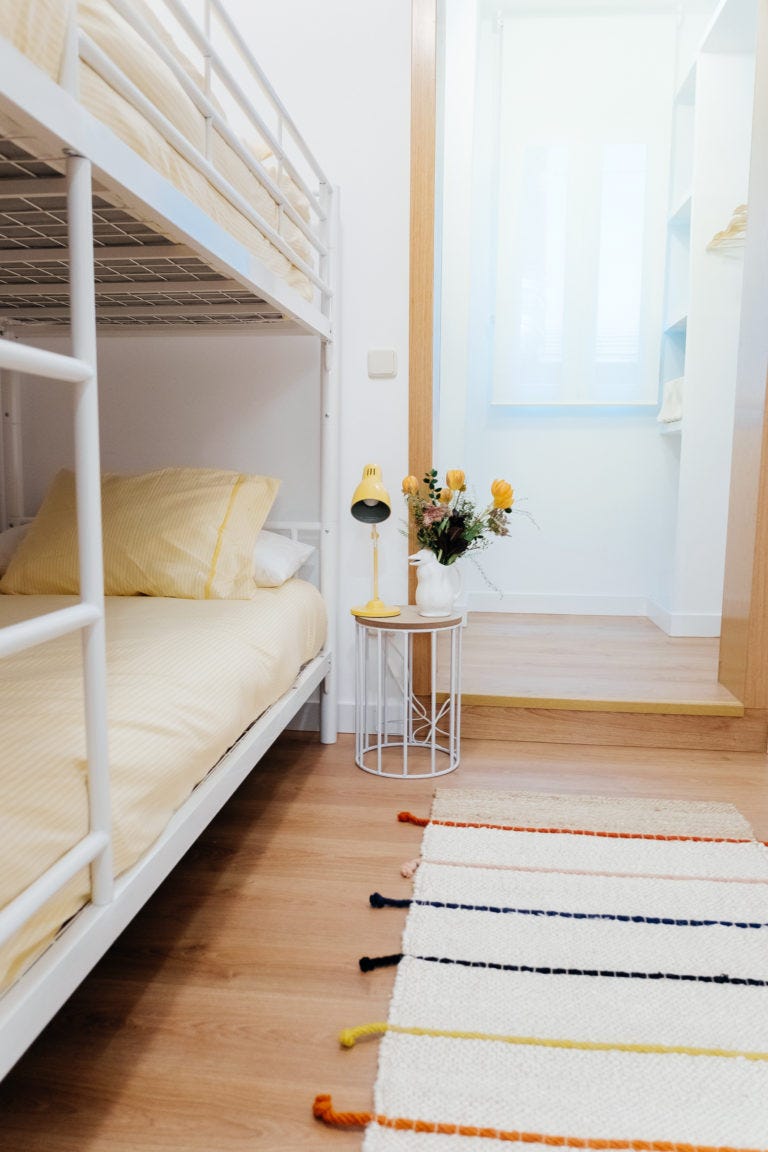 habitación con dos literas de forja blanca