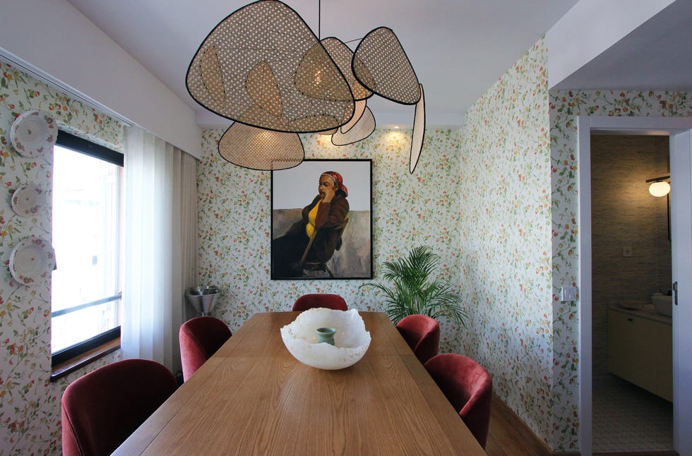 comedor con papel pintado floral y lámpara de techo de fibras