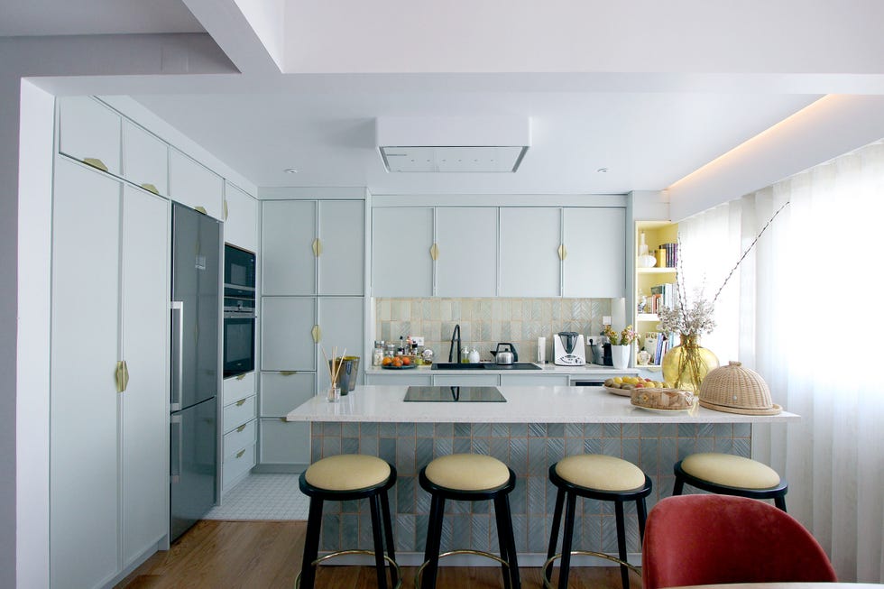 cocina abierta con isla central y puertas en color azul pastel