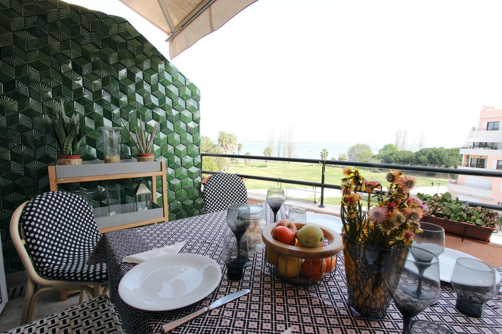 terraza con comedor y pared de azulejos verdes