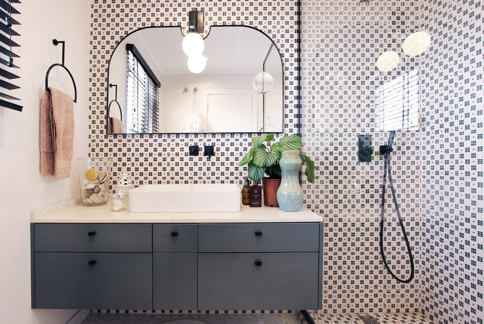 baño con ducha de obra, mueble bajo lavabo suspendido y paredes con azulejos de estilo vintage